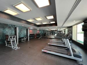 a gym with several treadms and machines in a room at Luton Vacation Homes - Cozy1BR , Al Dhafra Tower 1 - Dubai Greens - 40AB1 in Dubai