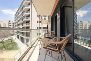 un balcone con sedie e tavolo su un edificio di The Lonely Chimney Apartments a Barcellona