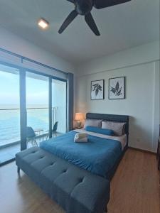 a bedroom with a blue bed with a ceiling fan at Kuantan Imperium seaview cityview by Avenzee in Kuantan