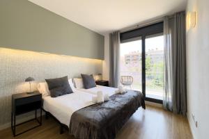a bedroom with a large bed and a large window at The Lonely Chimney Apartments in Barcelona