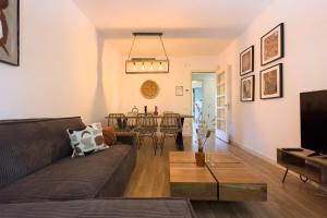 een woonkamer met een bank en een tafel bij The Lonely Chimney Apartments in Barcelona