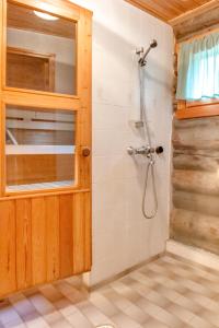 baño con ducha y puerta de cristal en Holiday Apartment Suommukelo 5 en Suomutunturi