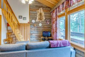 un soggiorno con divano blu in una baita di tronchi di Holiday Apartment Suommukelo 5 a Suomutunturi