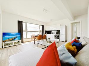 a living room with a couch and a tv and a table at Costa Alimos by Verde Apartments in Athens