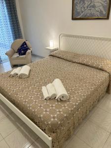 una camera da letto con un letto, asciugamani e una sedia di casa le tegole a Noto