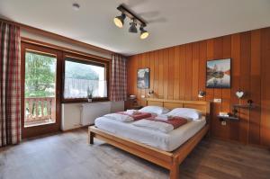 una camera da letto con un letto e una grande finestra di Pension & Apartments Weissbriach a Weissbriach