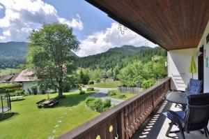 a balcony with chairs and a view of a yard at Pension & Apartments Weissbriach in Weissbriach