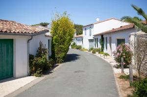 ulica w wiosce z białymi domami w obiekcie Huttopia Chardons bleus Ile de Re w mieście Sainte-Marie-de-Ré