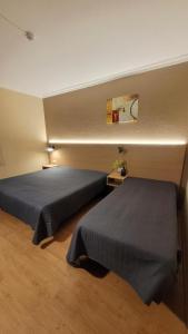 twee bedden in een kamer met twee bedden sidx sidx sidx bij Ferrinho in Guarda
