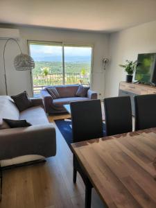 ein Wohnzimmer mit Sofas und einem Tisch mit Aussicht in der Unterkunft T3 avec magnifique vue montagne, 3 étoiles, piscine et parking, clim in Mougins