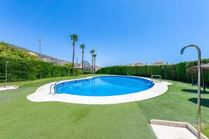 - une grande piscine dans une cour bordée de palmiers dans l'établissement 797 HOLIDAY RENTALS - Piso en arenal con vista al golf y mar, à Benalmádena