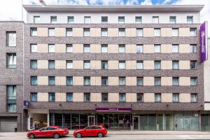 dos coches rojos estacionados frente a un edificio en Premier Inn Hamburg City Millerntor, en Hamburgo