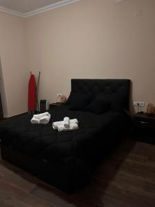 Un dormitorio con una cama negra con toallas. en Moratin n3 apartamento 150m2 en el centro, en Sevilla