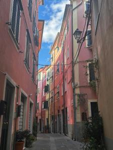 an alley with pink and yellow buildings on a street at Il Dolce Far Niente, La Serra di Lerici in Lerici
