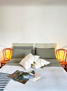 Una cama con una revista y almohadas. en Il Dolce Far Niente, La Serra di Lerici, en Lerici