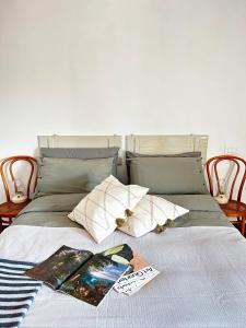 Una cama con algunos libros y almohadas. en Il Dolce Far Niente, La Serra di Lerici, en Lerici