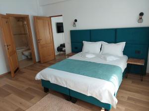een slaapkamer met een groot bed met een blauw hoofdeinde bij Vero Residence Predeal in Predeal