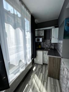 a kitchen with a large window and a kitchen counter at — Затишні Apartments — in Ivano-Frankivsʼk