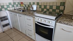 a kitchen with a white stove and a sink at Sol das Caldas in Caldas Novas