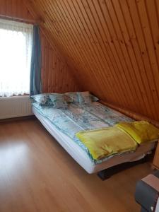 Pokoje u Bobików في زومب: سرير في غرفة بجدار خشبي