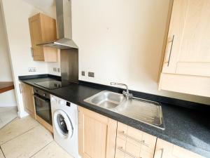 uma cozinha com um lavatório e uma máquina de lavar roupa em Convenient 3BR Flat on Leith Walk em Edinburgo