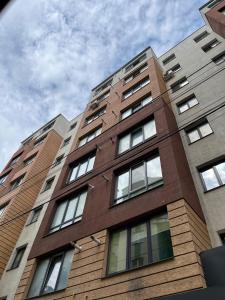 a tall brick building with many windows on it at — Затишні Apartments — in Ivano-Frankivsʼk