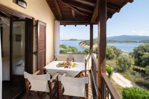 a balcony with a table and chairs and a view of the water at Heos Accommodation in Ormos Panagias