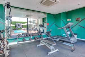 a fitness room with a gym with a mirror at Urban Oasis Apartments at One Hyde Park in Johannesburg