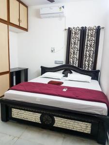 a bed in a room with a wooden frame at KORA'S HOME STAY in Tirupati