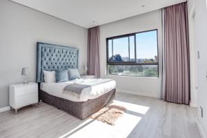 a bedroom with a large bed and a large window at Urban Oasis Apartments at One Hyde Park in Johannesburg +14 photos