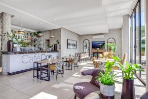 Johannesburg的住宿－Urban Oasis Apartments at One Hyde Park，一间带桌椅的餐厅和一间酒吧