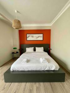 ein Schlafzimmer mit einem großen Bett und einer orangefarbenen Wand in der Unterkunft Renovu Premium Homes in Cihangir in Istanbul