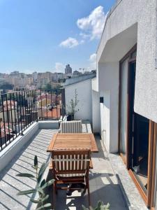 einen Balkon mit einem Holztisch und Stühlen auf einem Gebäude in der Unterkunft Renovu Premium Homes in Cihangir in Istanbul