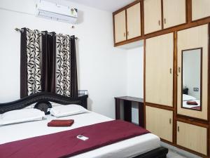 a bedroom with a bed and a mirror in it at KORA'S HOME STAY in Tirupati