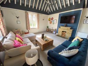uma sala de estar com um sofá e uma televisão em Castle At Edgehill em Banbury