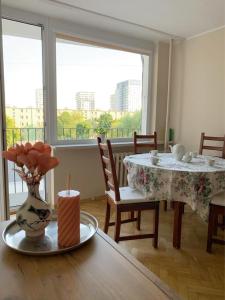 a dining room with a table with a vase of flowers at Park Regana in Gdańsk