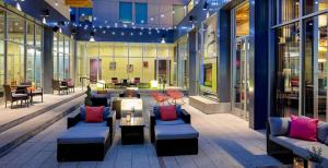 a lobby with couches and tables in a building at Aloft Chesapeake in Chesapeake