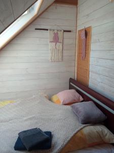 ein Schlafzimmer mit einem Bett in einer Holzwand in der Unterkunft Ozierański Eden "Pod rzeźbami" 