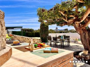 eine Terrasse mit einem Tisch und Stühlen unter einem Baum in der Unterkunft VH CostaBlanca - LLAGRIMA in Moraira