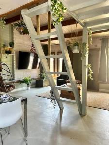 a living room with a staircase with potted plants at Jungle style lodge with jacuzzi ,sauna and garden near Amsterdam in Vijfhuizen