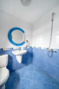 La salle de bains est pourvue de carrelage bleu, de toilettes et d'un lavabo. dans l'établissement Hotel Orlando, à Sofia