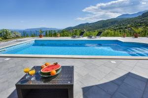- une table avec des fruits à côté de la piscine dans l'établissement Apartment Nave, à Ičići