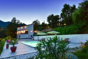 une villa avec une piscine et une maison dans l'établissement Apartment Nave, à Ičići