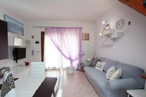 un soggiorno con divano blu e finestra di Villino Funtana 2 a San Teodoro