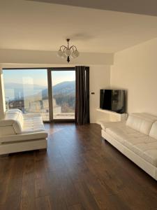 een woonkamer met een witte bank en een televisie bij Apartment Nave in Ičići