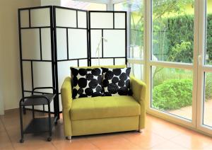 una silla amarilla en una habitación con ventana en Art & Nature Apartments in der Nähe FFM-Messe en Bad Vilbel