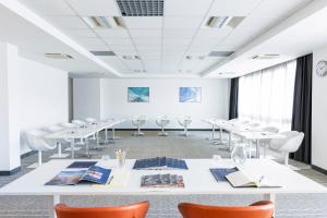 une salle de conférence avec des tables et des chaises blanches dans l'établissement The Caesar Roma, à Rome