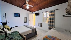 1 dormitorio con 2 camas y ventilador de techo en As Palmeiras Pousada, en Búzios