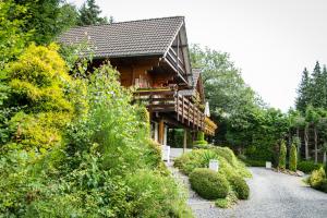 a wooden house with a balcony on the side of it at Arden Parks Petite Suisse in Dochamps