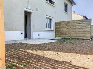 dom z drewnianym płotem przed nim w obiekcie Résidence Appartements Niort wifi-parking w mieście Niort